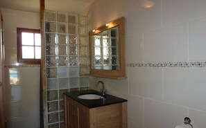 Regadera, secadora de cabello, toallas, papel de baño 