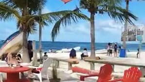 A beachside seating area with red chairs and tables, palm trees, and a view of the ocean. - Beautiful 2 bedroom unit, free wifi, pool 3 minutes walk from beach  (Punta Cana)