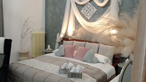 A bedroom with a bed, pillows, a nightstand, a radiator, and a decorative wall piece. - Vacation home San Giovanni nei Sassi (Matera)