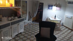 A dining area with a table set for two, a black chair, and a radiator. - Vacation home San Giovanni nei Sassi (Matera)