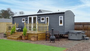 Une maison compacte de plain-pied, dotée d’un porche, d’un jacuzzi et d’une petite terrasse.
