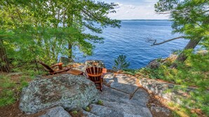 A wooden chair and table set on stone steps overlooking a body of water.