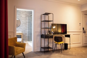 Relax in a comfortable room with a cozy armchair, desk, and flat-screen TV.