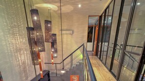 A modern interior with a kitchen, dining area, and a staircase leading to an upper level.