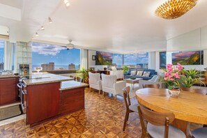 A spacious living area with a kitchen, dining table, and seating.