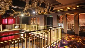 A multi-level interior with a balcony, red curtains, and patterned flooring. - International Hotel (Jiaxing)