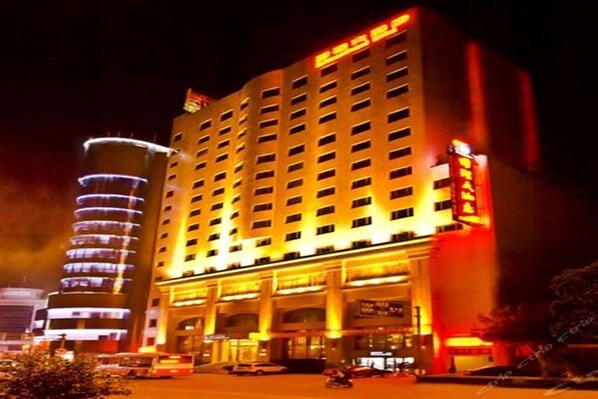 A multi-story hotel with a prominent entrance and a large sign.