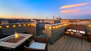 A rooftop patio with a fire feature, outdoor seating, and string lights. - Remarkable home near Old Town, Breweries, & River! (Fort Collins)