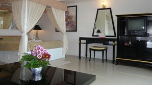 Une chambre d’hôtel équipée d’un lit, d’un bureau, d’une chaise, d’une télévision et d’un miroir.