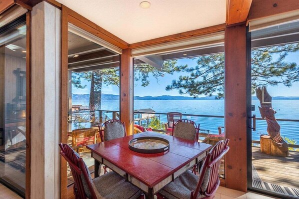 Enjoy meals with family and friends at this spacious dining area, surrounded by scenic views of a body of water and mountains.