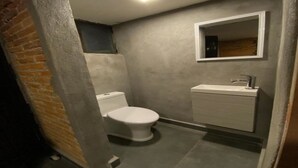 Une petite salle de bain comprenant des toilettes, un lavabo et un miroir.