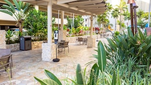 Eine Außenpatio-Terrasse mit Steinböden, Sitzgelegenheiten und verschiedenen Pflanzen.