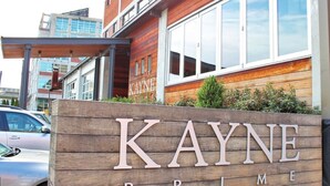 Ein Holzschild mit der Aufschrift "KAYNE PRIME" für ein Hotel.