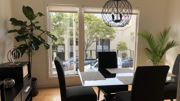 A modern dining area with a table, chairs, and a hanging light fixture. - Beautiful Marina Home - 2Bed 2Bath - 1 block from Marina Blvd! (San Francisco)