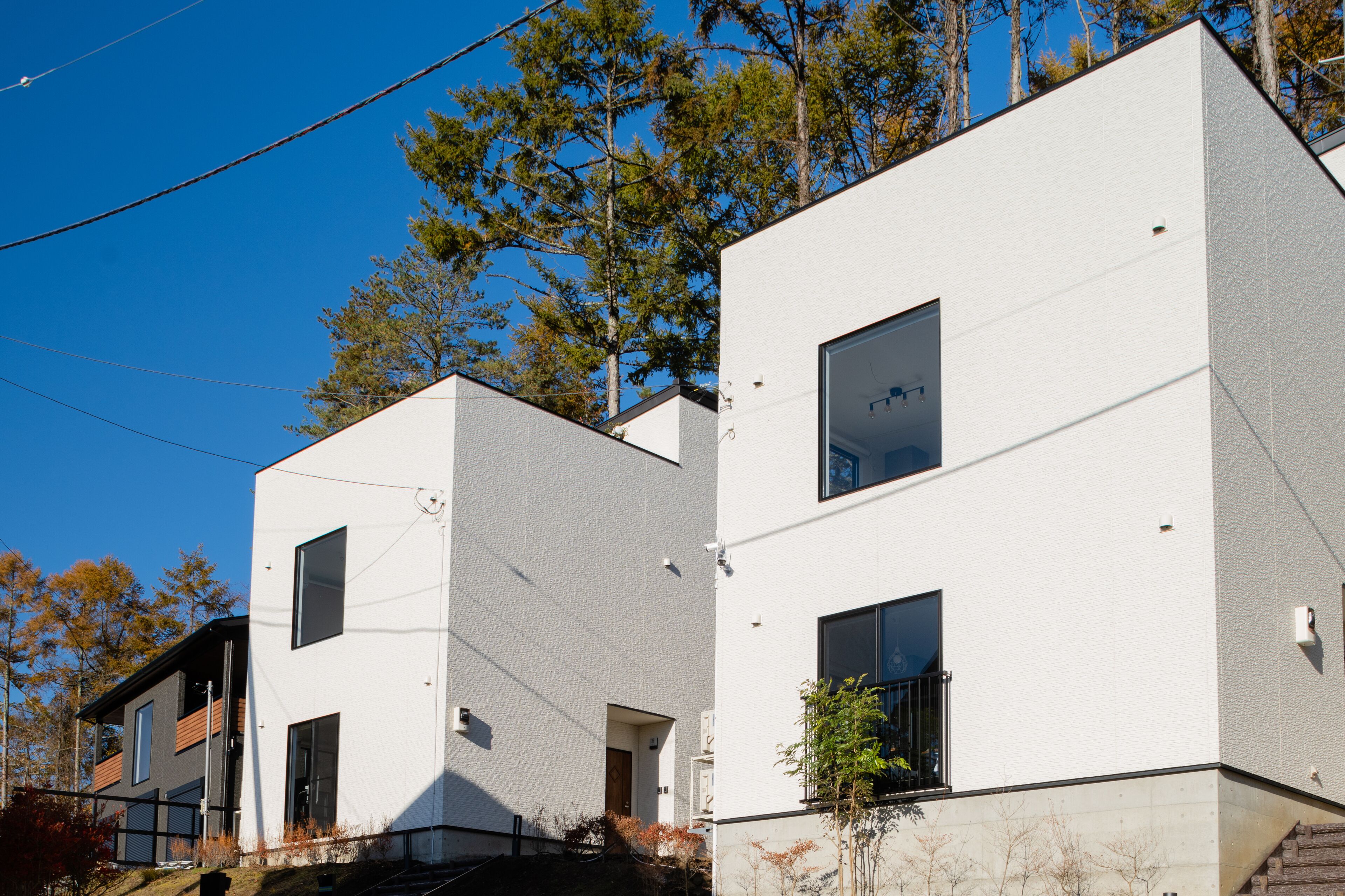 A modern two-story building with large windows and a flat roof.