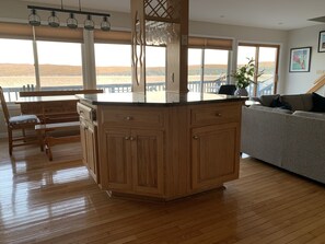 A kitchen with wooden cabinets, a countertop, and a view of the outdoors.