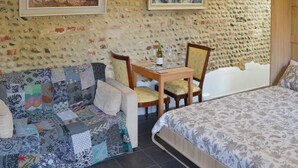 A cozy room with a bed, a sofa, and a small table with chairs.