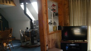 Un salón acogedor con chimenea, televisor y una decoración de bicicleta en la pared.