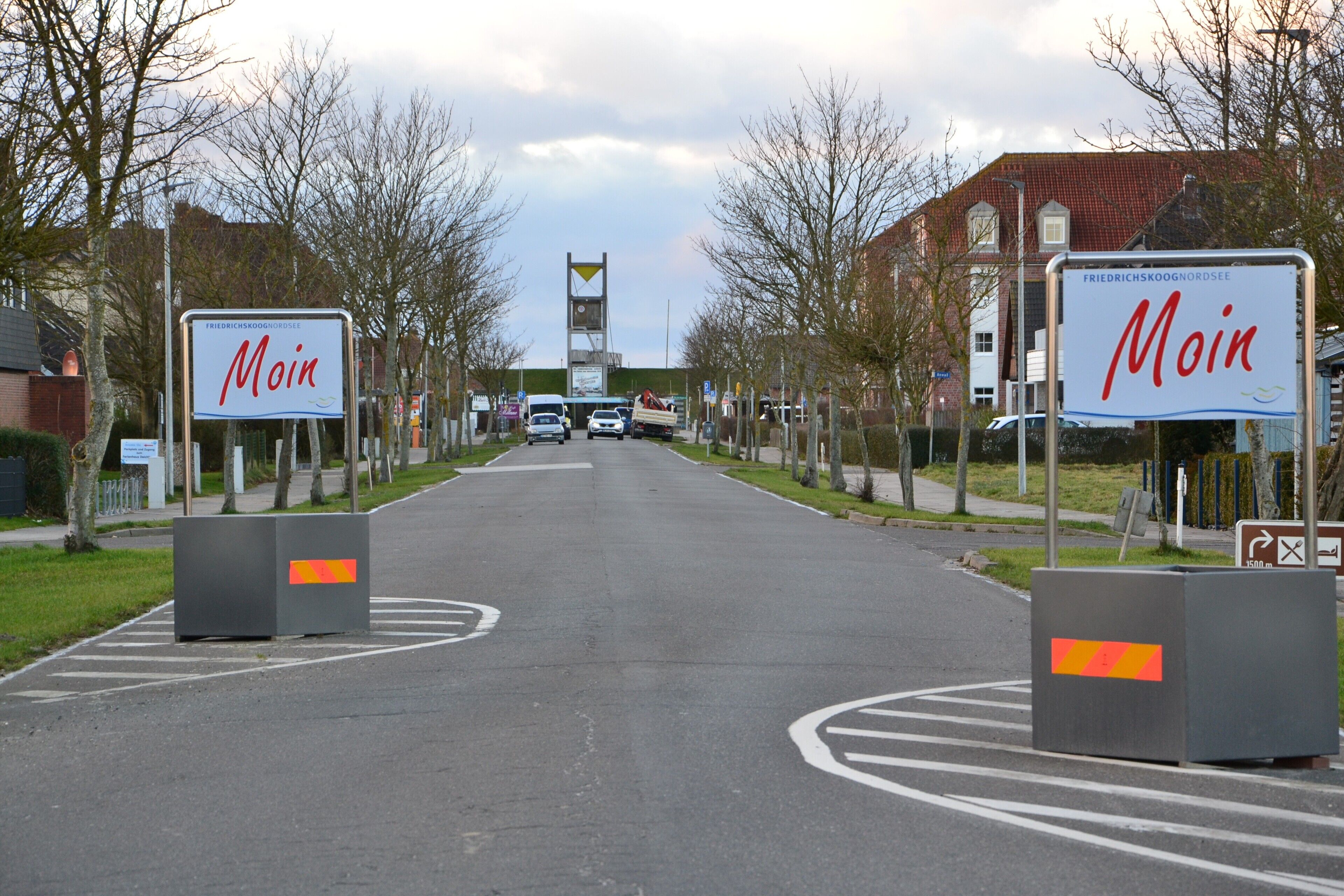 Une route menant à un bâtiment, de part et d’autre duquel on peut voir des panneaux indiquant « Moin ».