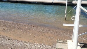 A waterfront view with a marina, a sandy beach, and a hotel in the background. - Riverfront house with casino view (Bullhead City)