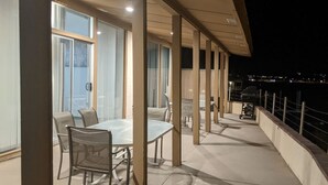 An outdoor patio with tables and chairs, a grill, and a view of the city at night. - Riverfront house with casino view (Bullhead City)