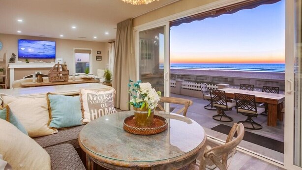 A living room with a glass table, sofa, and a view of the ocean. - 55' Ocean Front * Exclusive Ground Level Patio * A/C (San Diego)