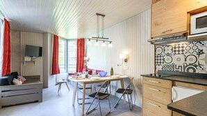 Een moderne keuken met een magnetron, houten kastjes en een decoratieve spatwand.