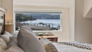 A bedroom with a large window offering a view of a waterfront and dock. - The BayAway 4 BR Waterview Home in DT Port Orchard (Port Orchard)
