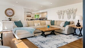 A modern living room with a sofa, coffee table, and decorative wall art. - The BayAway 4 BR Waterview Home in DT Port Orchard (Port Orchard)