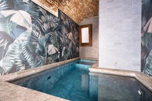 A swimming pool with a tropical mural, tiled walls, and a wooden-framed window. - Villa Bordonaro (Cefalù)