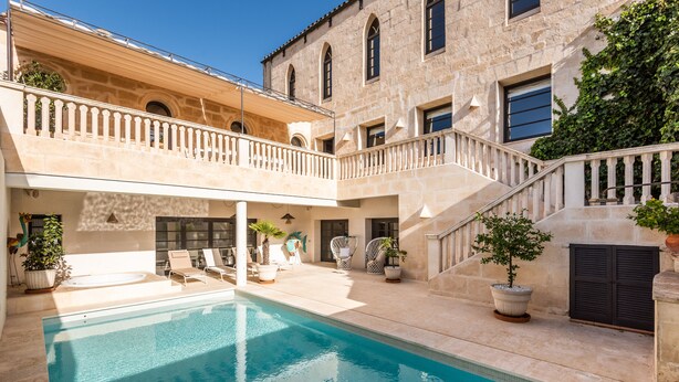 A pool area with a stone building, a staircase, and outdoor seating. - Splendid Former Chapel With Pool and hot tub (Port Mahon)