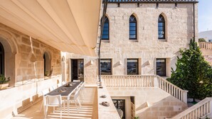 A stone building with a balcony, outdoor seating, and a staircase. - Splendid Former Chapel With Pool and hot tub (Port Mahon)