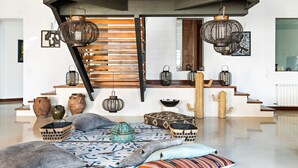 A modern interior with a staircase, hanging lanterns, and decorative pottery. - Splendid Former Chapel With Pool and hot tub (Port Mahon)