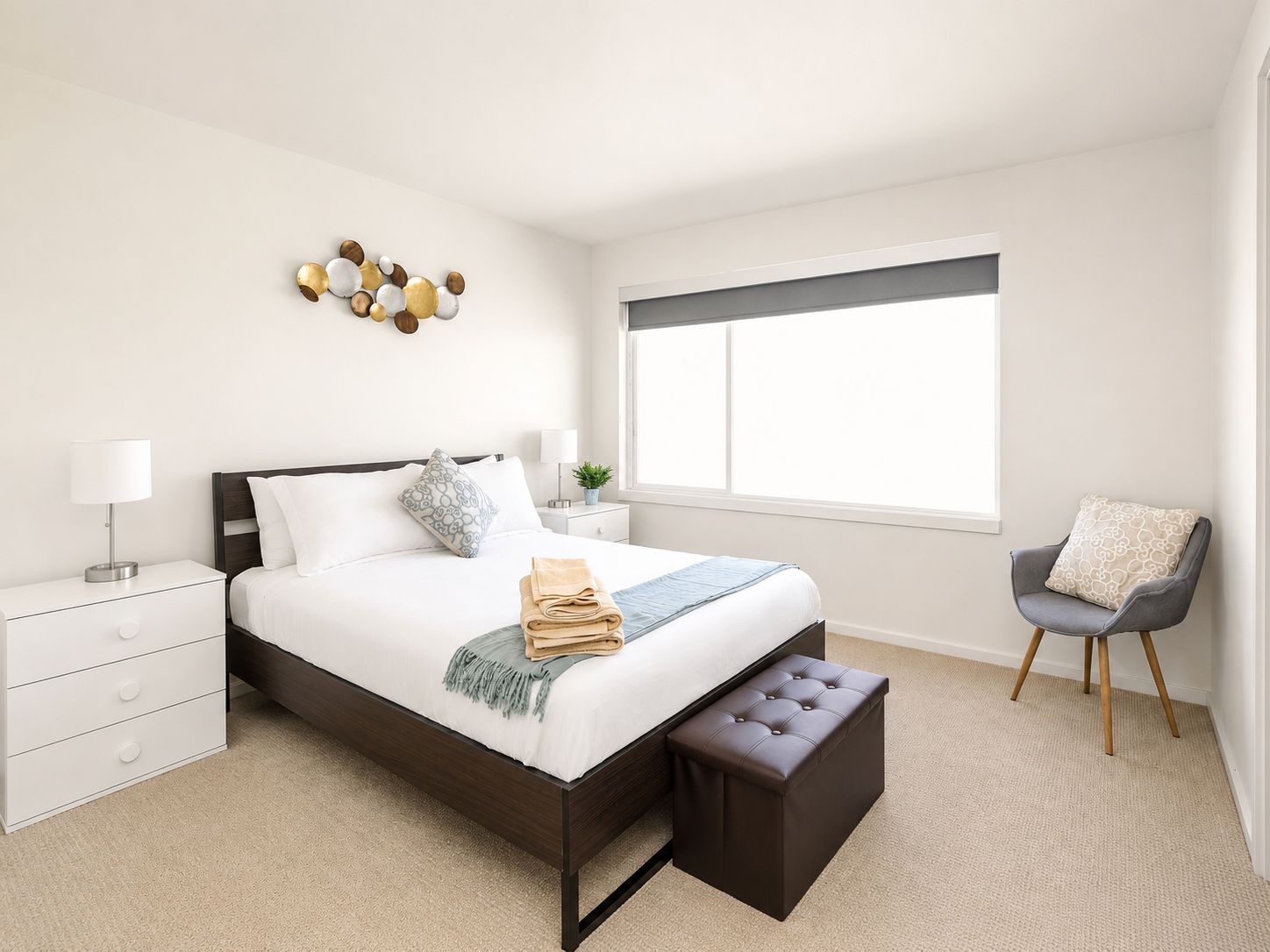 Une chambre à coucher moderne avec un lit, des tables de chevet, un banc, une chaise et une fenêtre.
