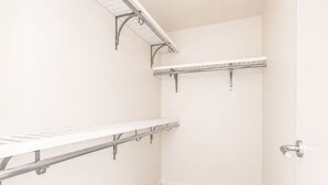 A corner of a room with a white wall, a beige carpet, and metal shelving units. - Modern Penthouse on Mass By CozySuites (Indianapolis)