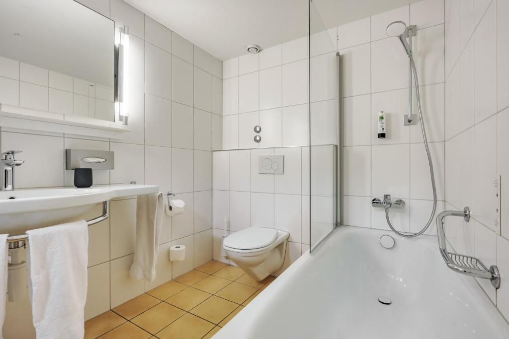 Ein modernes Badezimmer mit Toilette, Waschbecken und Dusche.