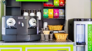 A breakfast station with coffee machines, Lipton tea boxes, and a water station. -  flexy.motel Wil (Wil)