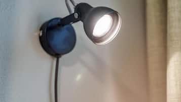 A wall-mounted lamp with a cord plugged into a power outlet.