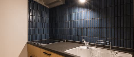 Una cocina con dos fregaderos, armarios de madera y un salpicadero de azulejos azules.