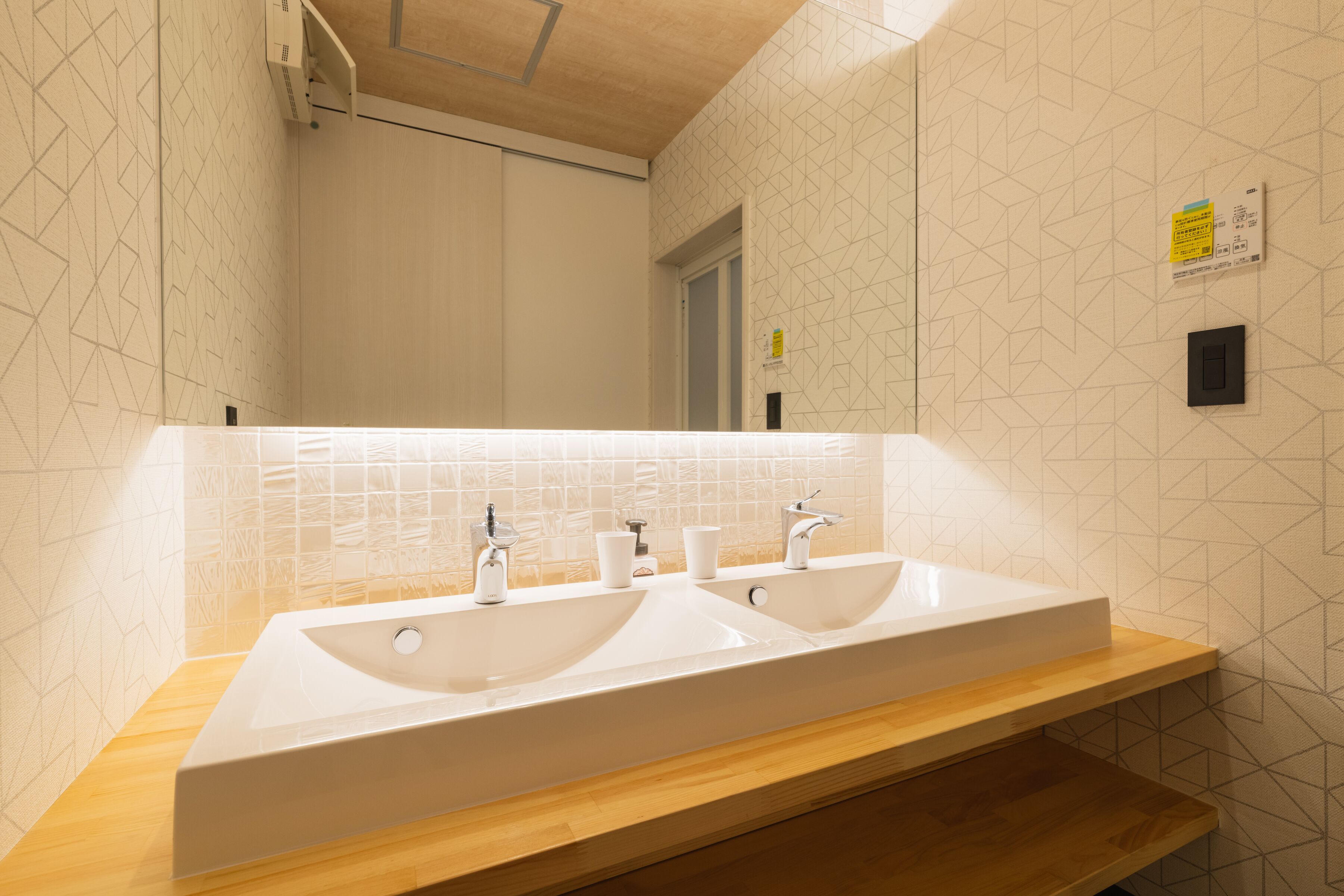 Une salle de bain avec deux lavabos, un miroir et un meuble-lavabo en bois.