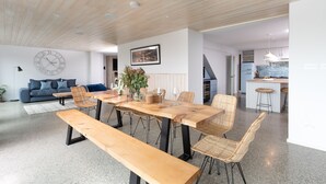 Een moderne keuken met witte kasten, een centraal eiland en barstoelen.