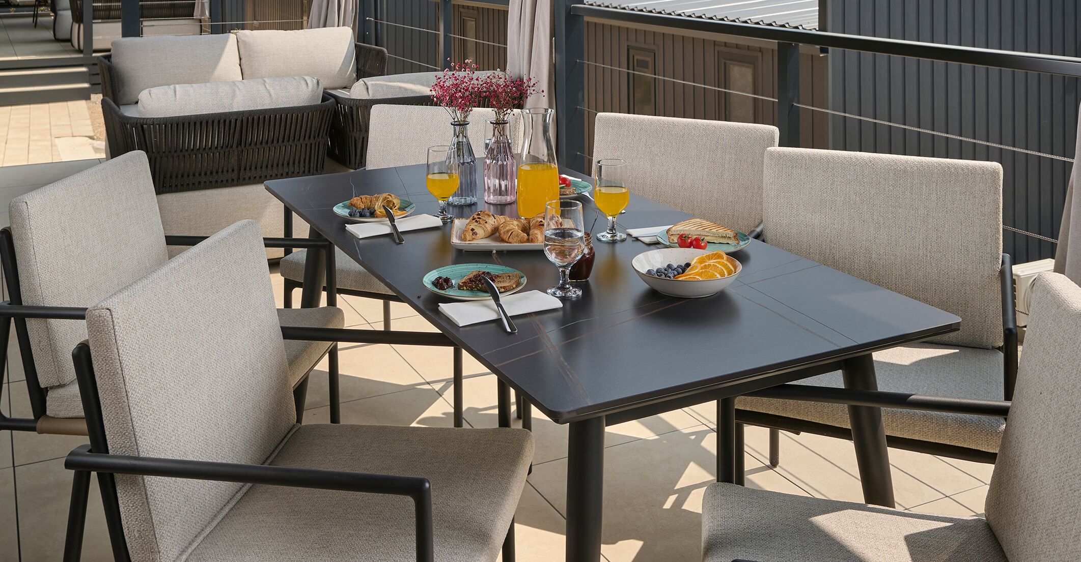 Een terras met een ontbijttafel, compleet met croissants, fruit en drankjes.