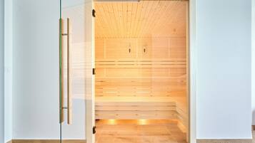 A wooden sauna with a glass door, wooden floor, and a simple, clean design.