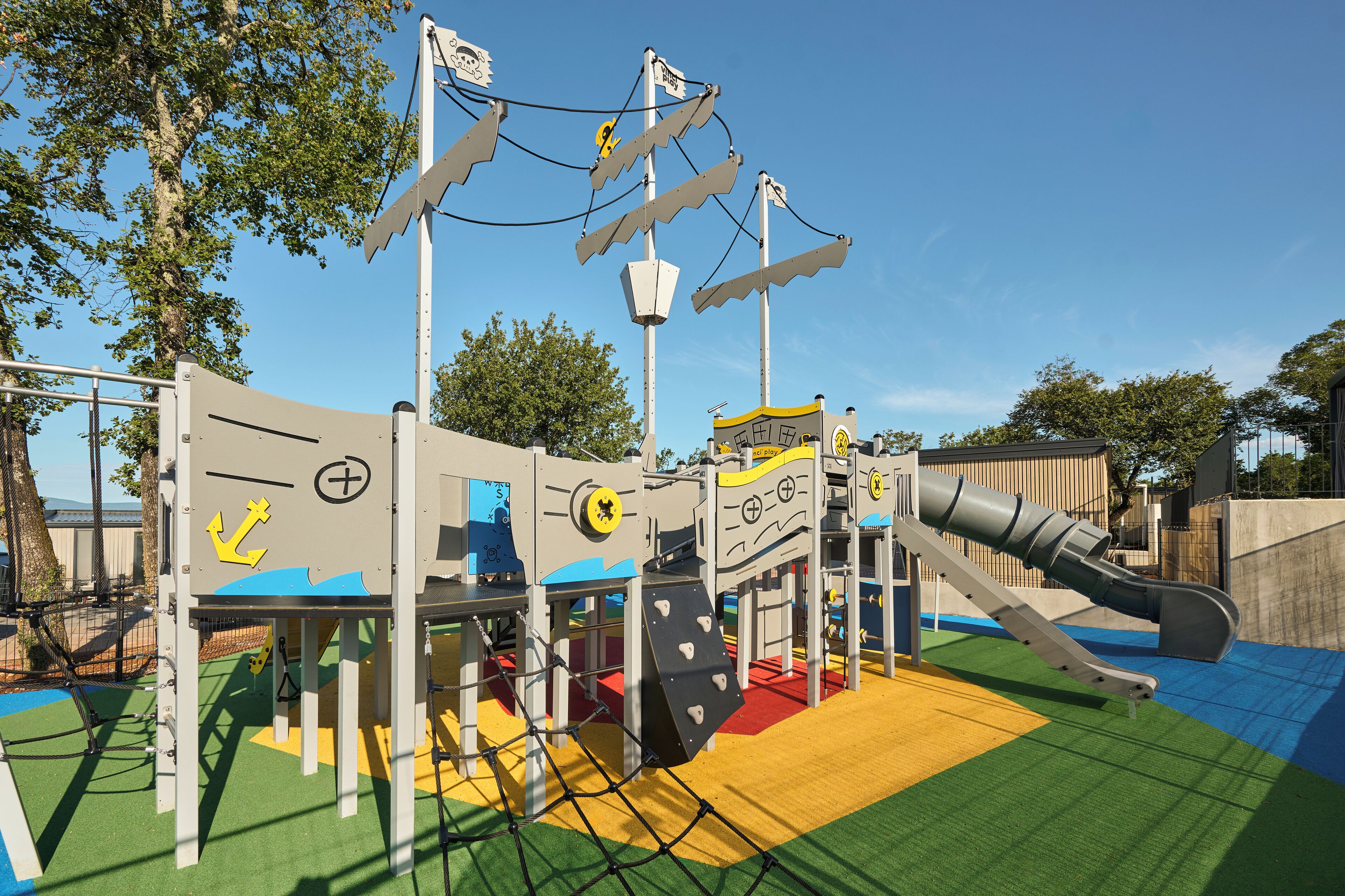A playground with a slide, climbing structures, and a netted area.