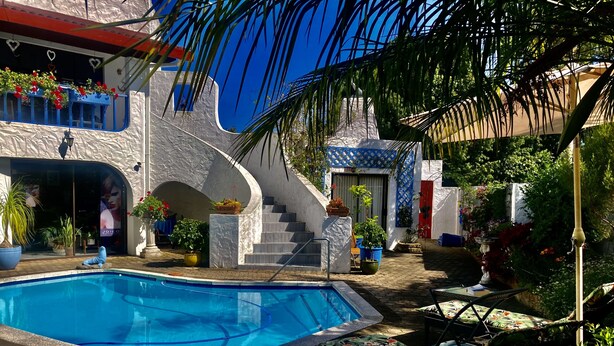 Un espace piscine agrémenté d’une terrasse en pierre, d’un escalier et de plantes en pot.