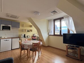 A compact kitchen with a microwave, coffee maker, and a dining table with chairs. - Top-floor apartment with parking and air conditioning in Aix-les-Bains! (Aix-les-Bains)