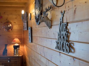 A wooden wall with a deer head decoration and a 'Merry Christmas' sign.