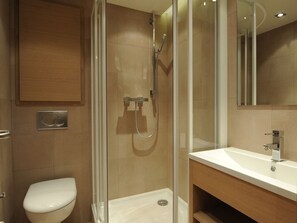 A modern bathroom with a glass-enclosed shower, a toilet, and a vanity with a mirror. - Elegant apartment in Courchevel Village, 3 bedrooms, pets allowed (Courchevel 1550)