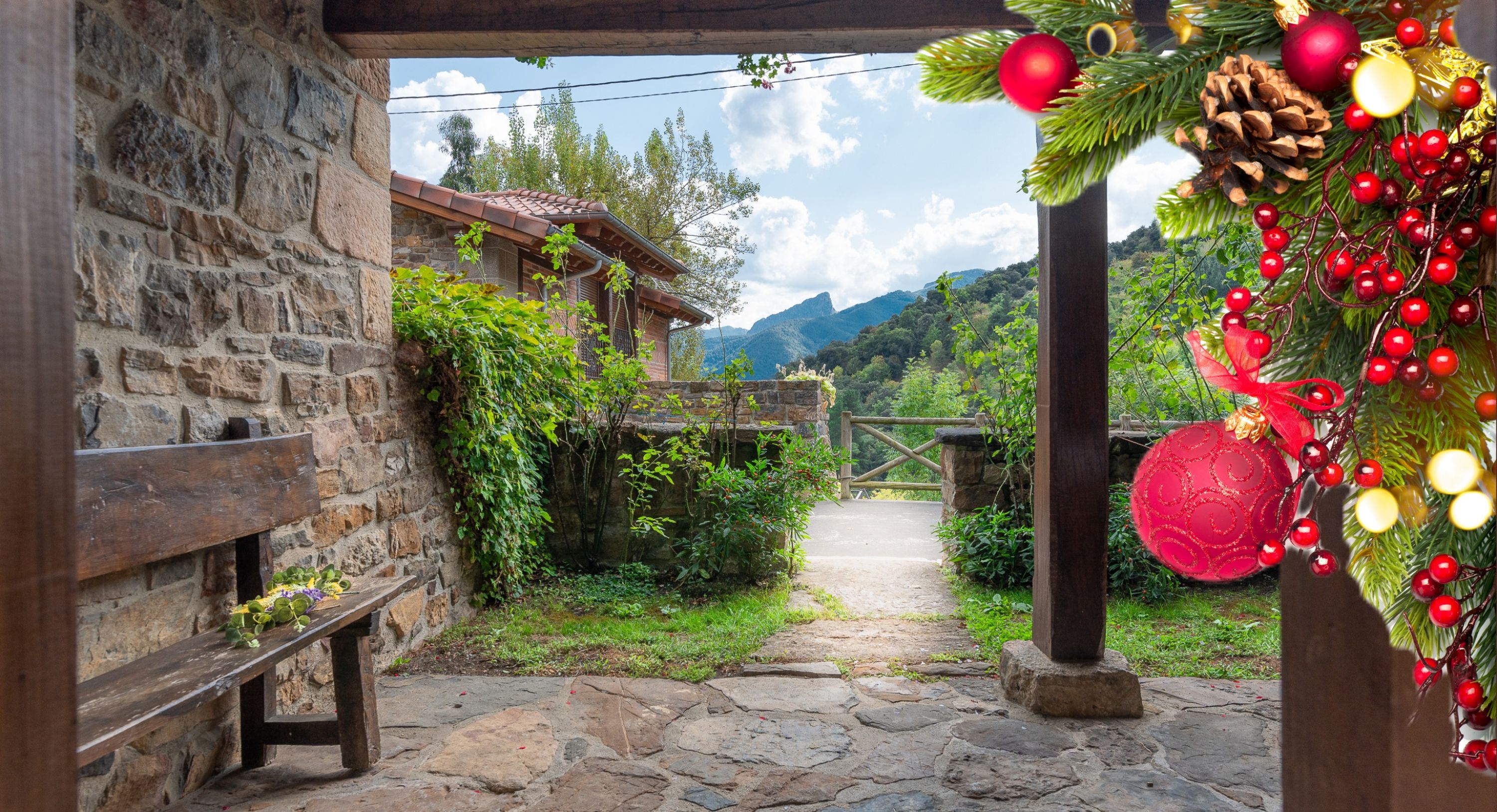 A stone pathway leading to a rustic wooden building with a stone wall and a bench.