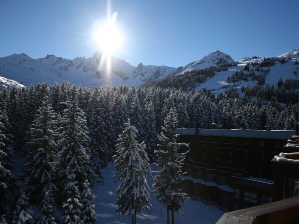 A snow-covered mountain landscape with a lodge in the foreground.